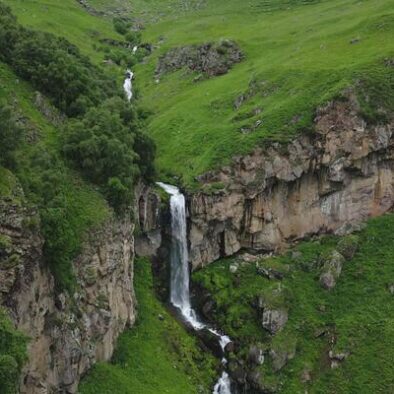 aerial-static-view-arsha-waterfall-stream-in-green-caucasus-mountains-kazbegi-national-park-things-to-see-and-do-popular-sightseeing-hiking-attraction-georgia-travel-destination-concept-free-video